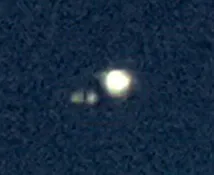A low-quality photo of Jupiter and two moons